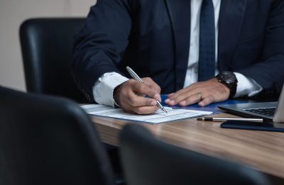 Lawyer sits at his desk with his laptop, filling out paperwork.